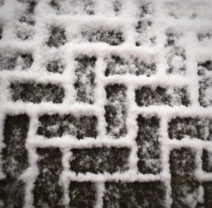 Safe Paw ice melt applied safely on interlocking paver driveway in winter.